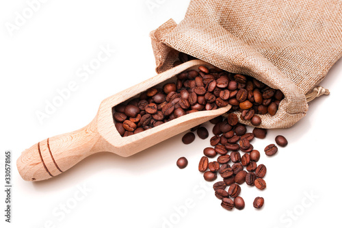 Coffee beans in linen sack with wooden scoop on white background