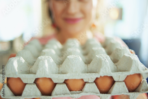 smiling woman showing big egg carton box