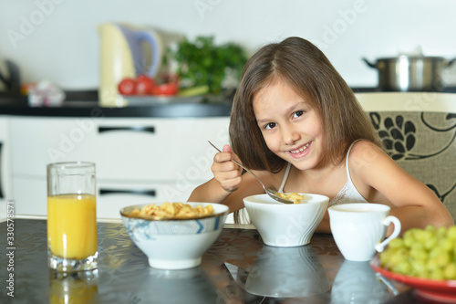 Portrait of young girl eating in the kitchen