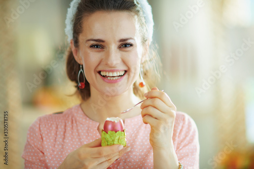 Photography smiling modern female eating easter egg with spoon