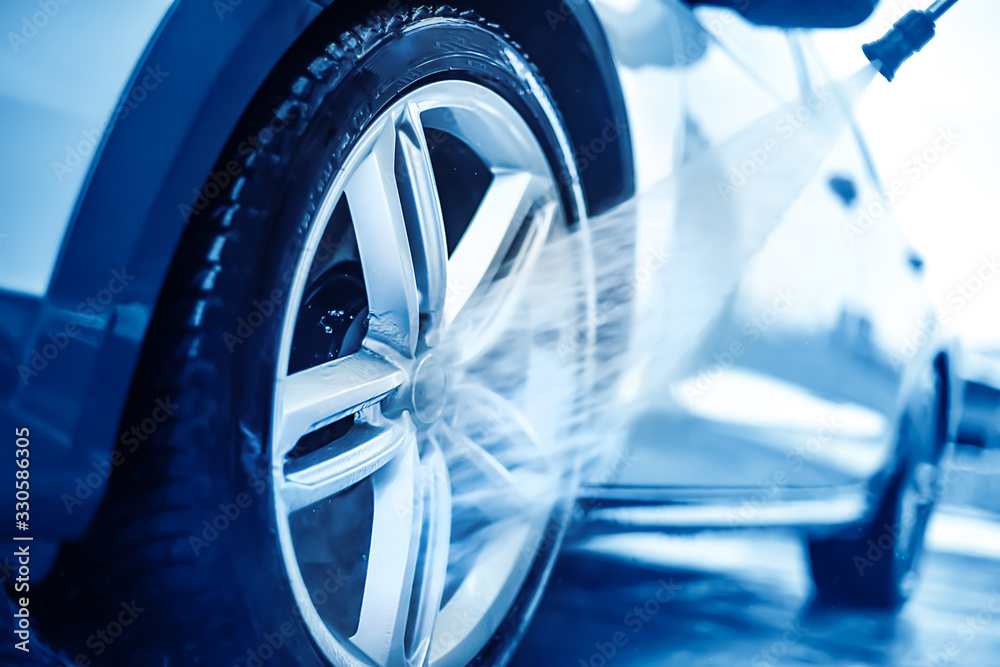 Car wheel wash. Cleaning with water jet. Cars rim or alloy washing close up.