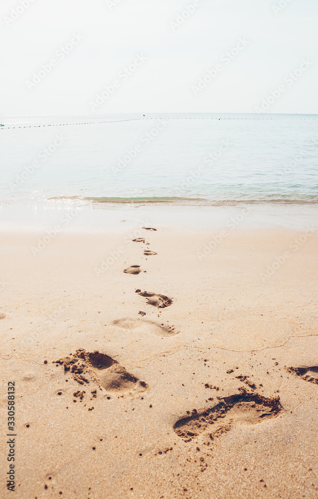 Holiday symbol of quiet rest in attractive areas on the beach, with visible footprints in the sand. Concept for travel vacation - footsteps in sand on summer tropical getaway holidays vacation Holiday symbol of quiet rest in attractive areas on the beach, with visible footprints in the sand. Concept for travel vacation - footsteps in sand on summer tropical getaway holidays vacation
