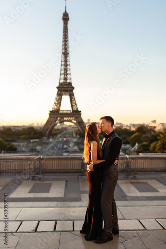 Romantic couple kisses near the Eiffel tower. Love, date, honeymoon in Paris