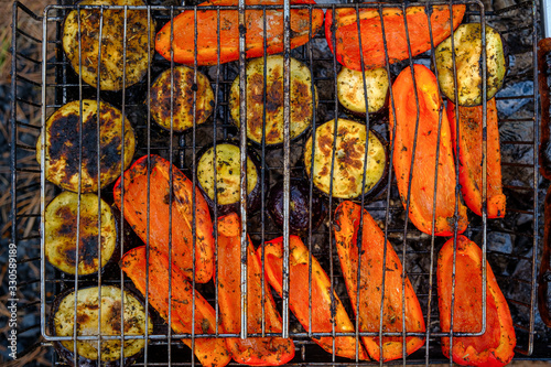 Vegetables and mushrooms fried in a grill on a grill, close-up