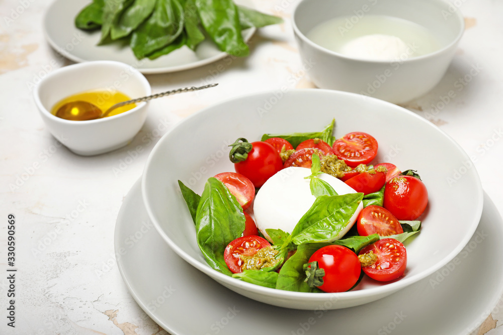 Mozzarella cheese with tomatoes, basil and pesto sauce on plate Mozzarella cheese with tomatoes, basil and pesto sauce on plate