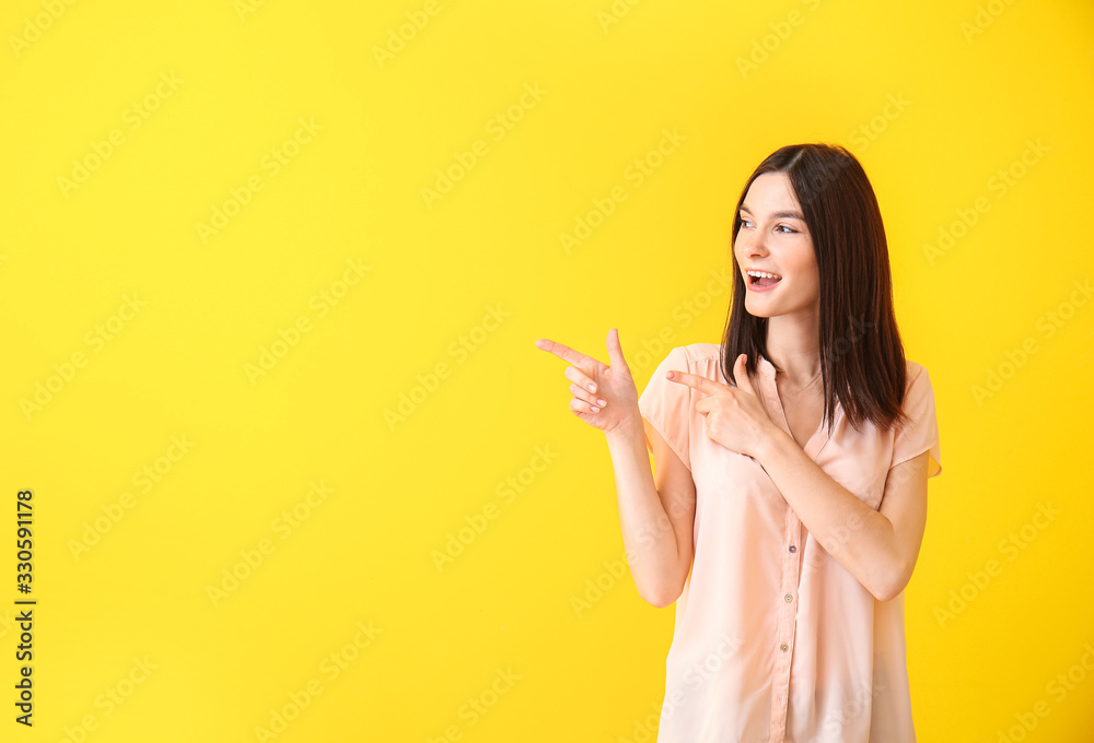 Portrait of beautiful young woman showing something on color background Portrait of beautiful young woman showing something on color background