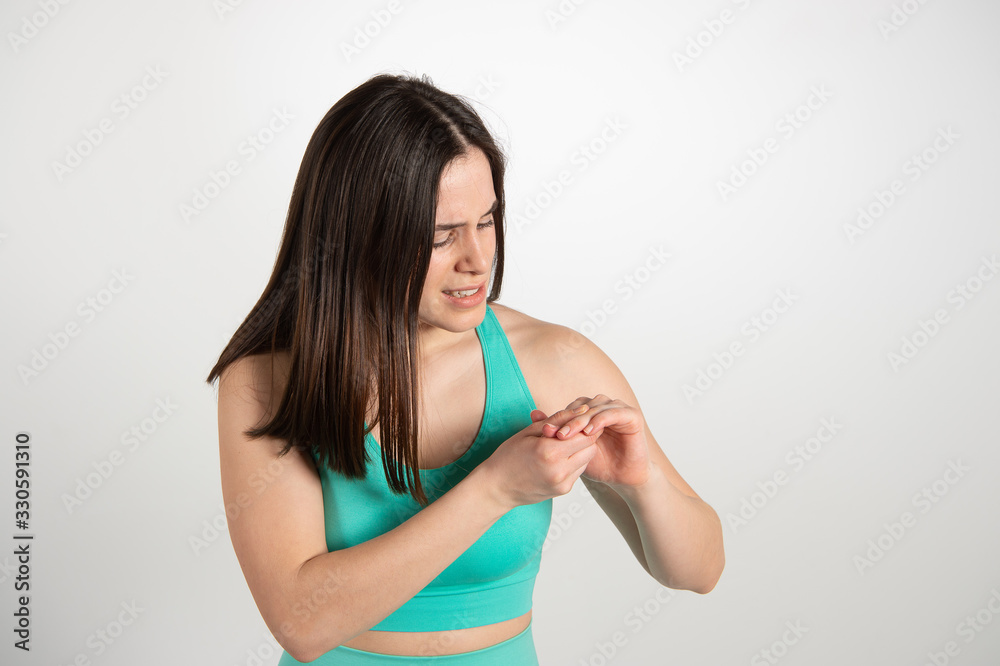 Young woman examining her hand in pain after hurting herself in the gym Young woman examining her hand in pain after hurting herself in the gym