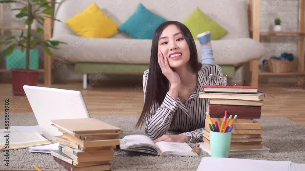 Portrait of a beautiful Asian girl student with books looking at the camera Portrait of a beautiful Asian girl student with books looking at the camera
