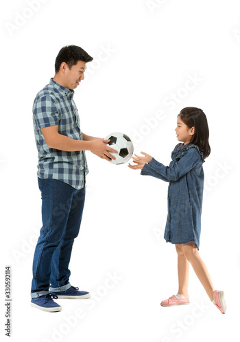 Happy Asian man and his little daughter with ball on white background