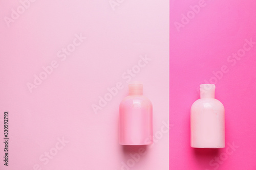 Bottles of shampoo on color background