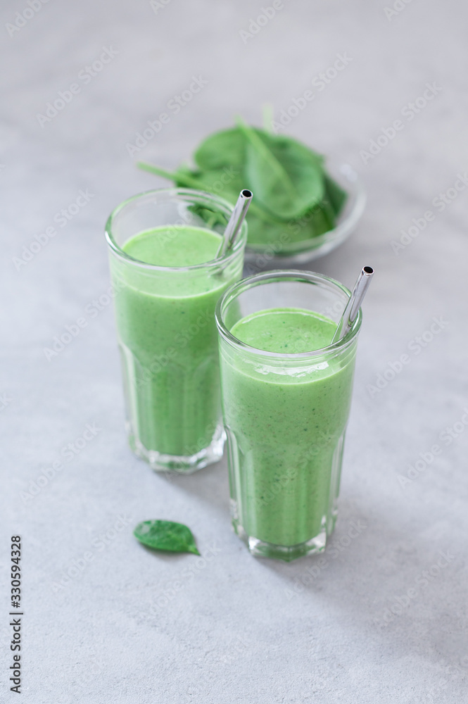 Fototapeta premium Vegan spinach smoothie drink in a glass on a light background