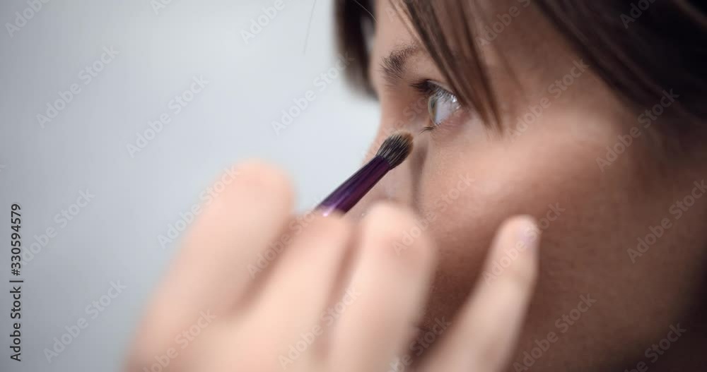 professional makeup artist applying makeup on models face before fashion show professional makeup artist applying makeup on models face before fashion show