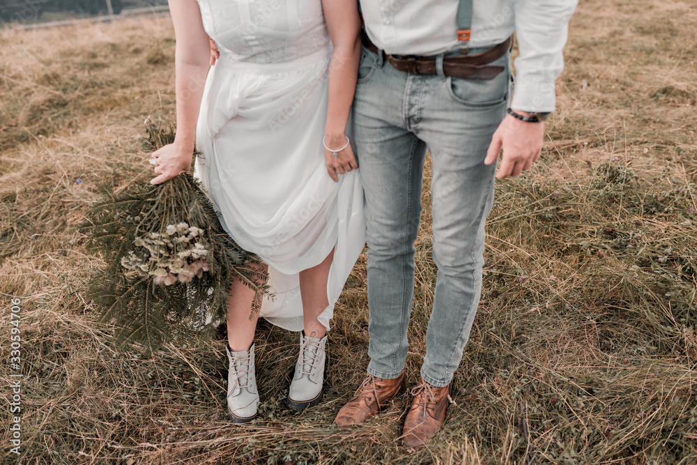 Beautiful bride and groom. close-up wedding shoes. bride with flowers in mountains, beautiful nature, landscape, sunset Beautiful bride and groom. close-up wedding shoes. bride with flowers in mountains, beautiful nature, landscape, sunset
