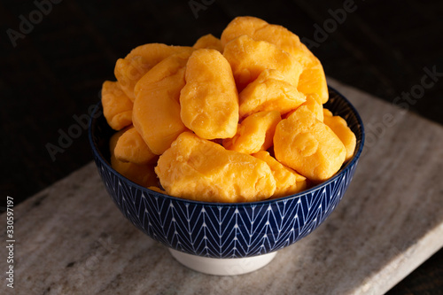 Bowl of Cheddar Cheese Curds on a Rustic Wooden Table