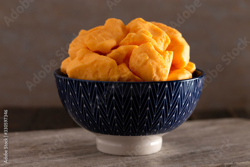 Bowl of Cheddar Cheese Curds on a Rustic Wooden Table