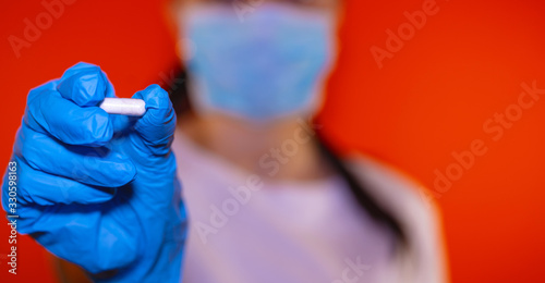 Close up of female doctor holding pill in hand. Pharmacist holding a pill. Female hand holding a white pill