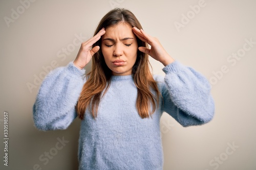 Beautiful young woman wearing casual winter sweater standing over isolated background with hand on head for pain in head because stress. Suffering migraine.