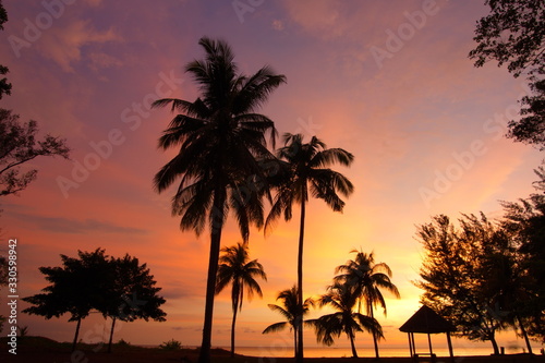 Sunset at beach with silhouette trees at Tanjung Aru beach in Sabah Malaysia