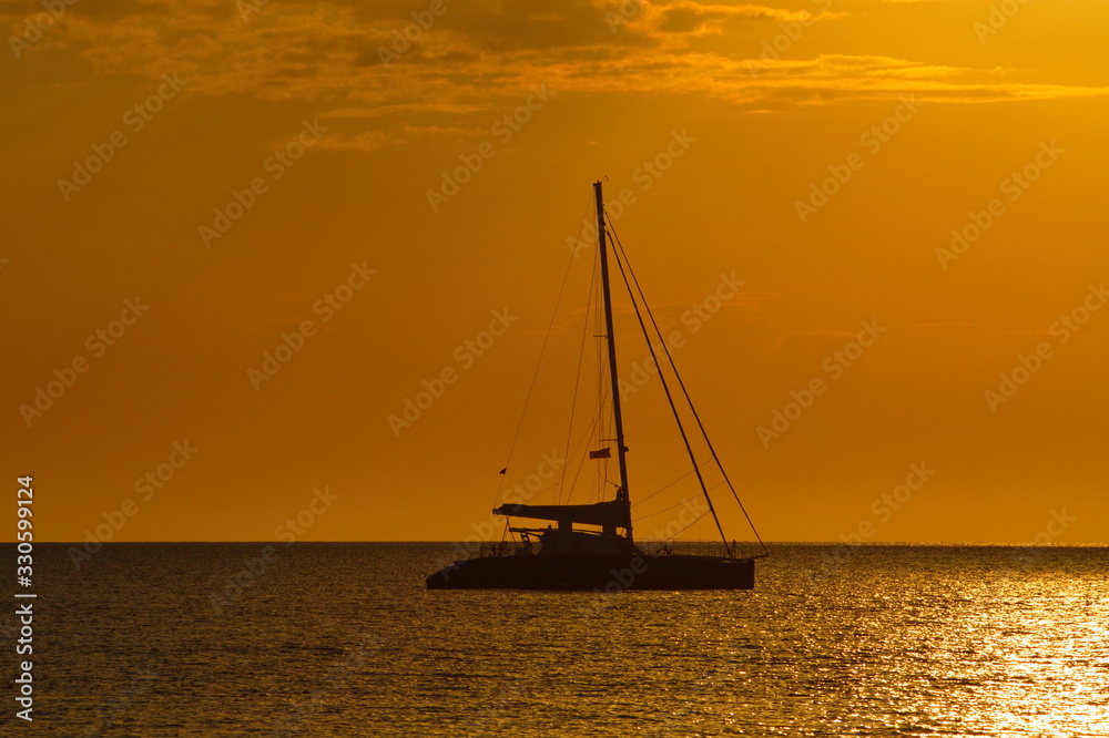 Beautiful sunset with silhouette sailing boat over the sea in Sabah Malaysia