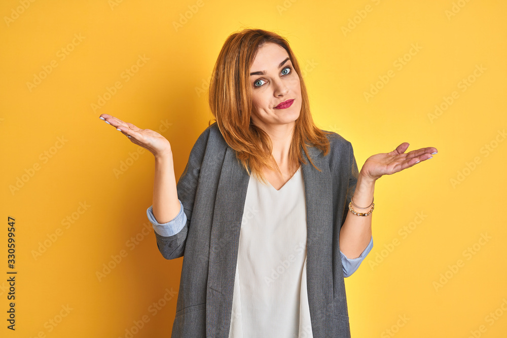Redhead caucasian business woman over yellow isolated background looking to the side with arms crossed convinced and confident Redhead caucasian business woman over yellow isolated background looking to the side with arms crossed convinced and confident