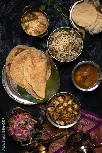 Indian vegan thali meal with rice pilaf, paratha, dal, mushroom tofu curry photo