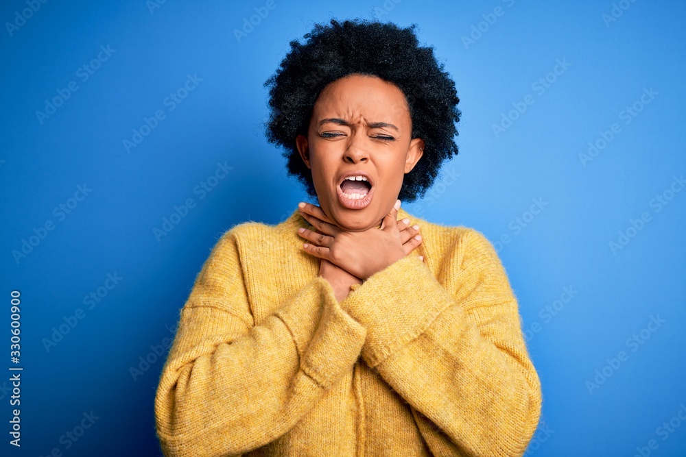 Young beautiful African American afro woman with curly hair wearing yellow casual sweater shouting suffocate because painful strangle. Health problem. Asphyxiate and suicide concept. Young beautiful African American afro woman with curly hair wearing yellow casual sweater shouting suffocate because painful strangle. Health problem. Asphyxiate and suicide concept.