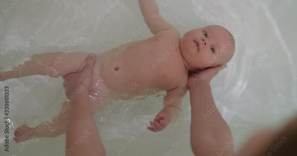 Top view of funny newborn baby swimming during bathing Top view of funny newborn baby swimming during bathing