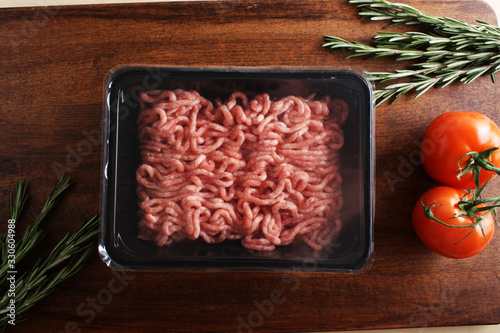 minced meat in packing on a wooden background
