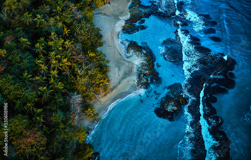 Fotografi Scenic aerial shot of a sunny beach with white sand surrounded by transparent blue ocean water