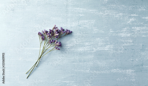 Delicate violet flowers on rustic wooden background. Copy space