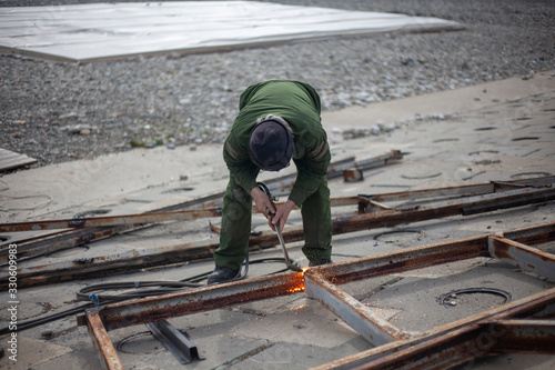 A welder works on the waterfront.