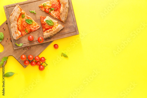 Boards and slices of delicious pizza Margherita on color background
