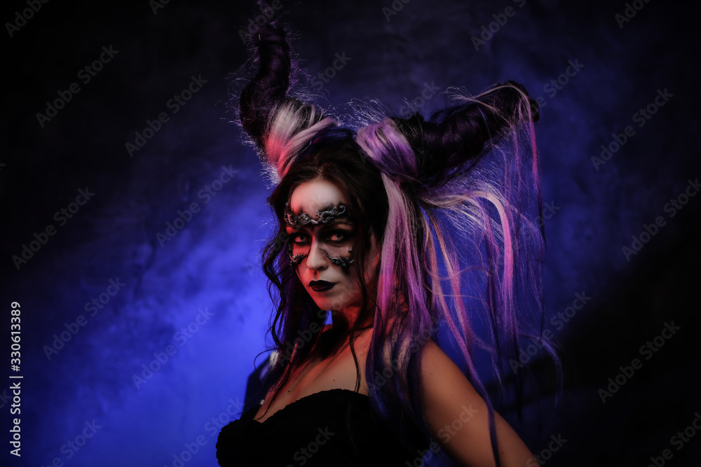 Portrait photo of a mystic young girl in a magic creature cosplay, wearing dark banshee make-up and violet horns, looking scary surrounded by smoke