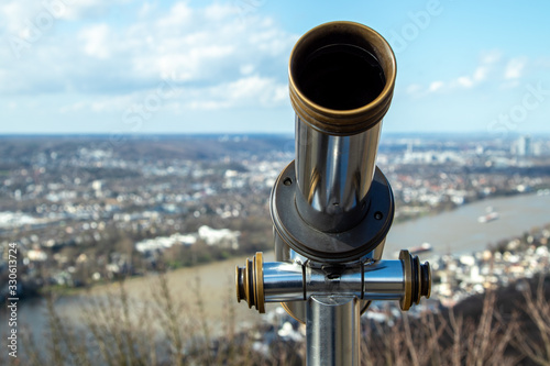observation telescope for tourists at drachenfels platform, blurred landscape as backgroound photo