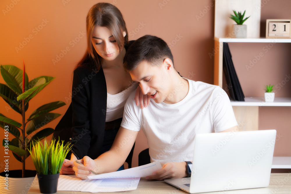 Loving couple working successfully together on their own business in the office Loving couple working successfully together on their own business in the office