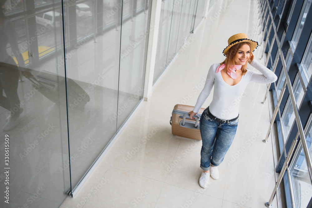 Fototapeta premium Woman walking with suitcase on the airport terminal,travel concept. High season and vacation concept. Relax and lifestyles. Travel and Holiday Concept.