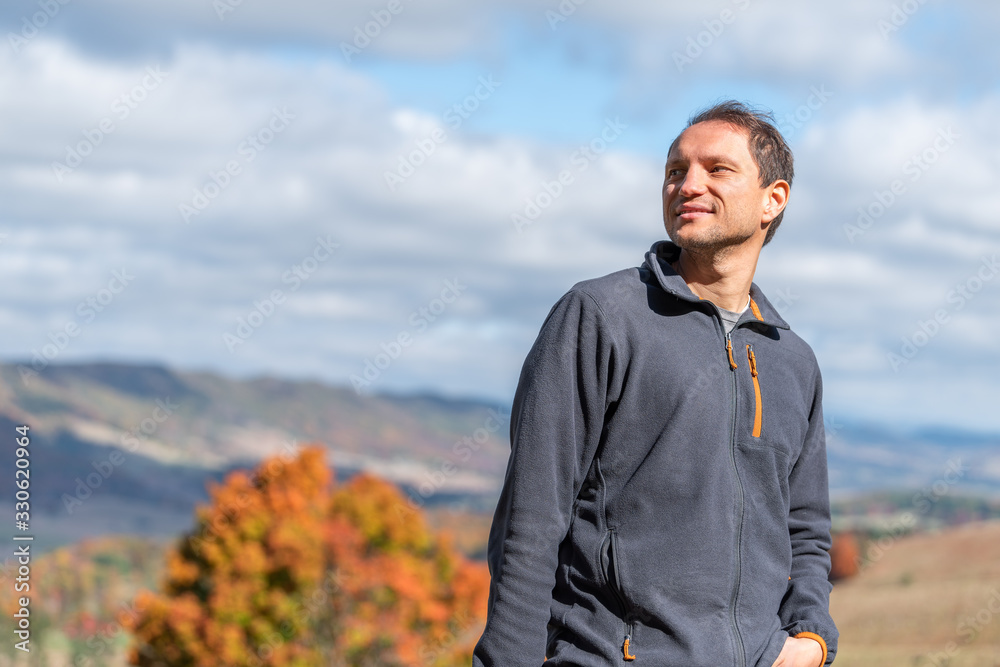 Orange autumn maple trees with happy man looking at background of rolling hills landscape in Monterey and Blue Grass, Highland County, Virginia Orange autumn maple trees with happy man looking at background of rolling hills landscape in Monterey and Blue Grass, Highland County, Virginia
