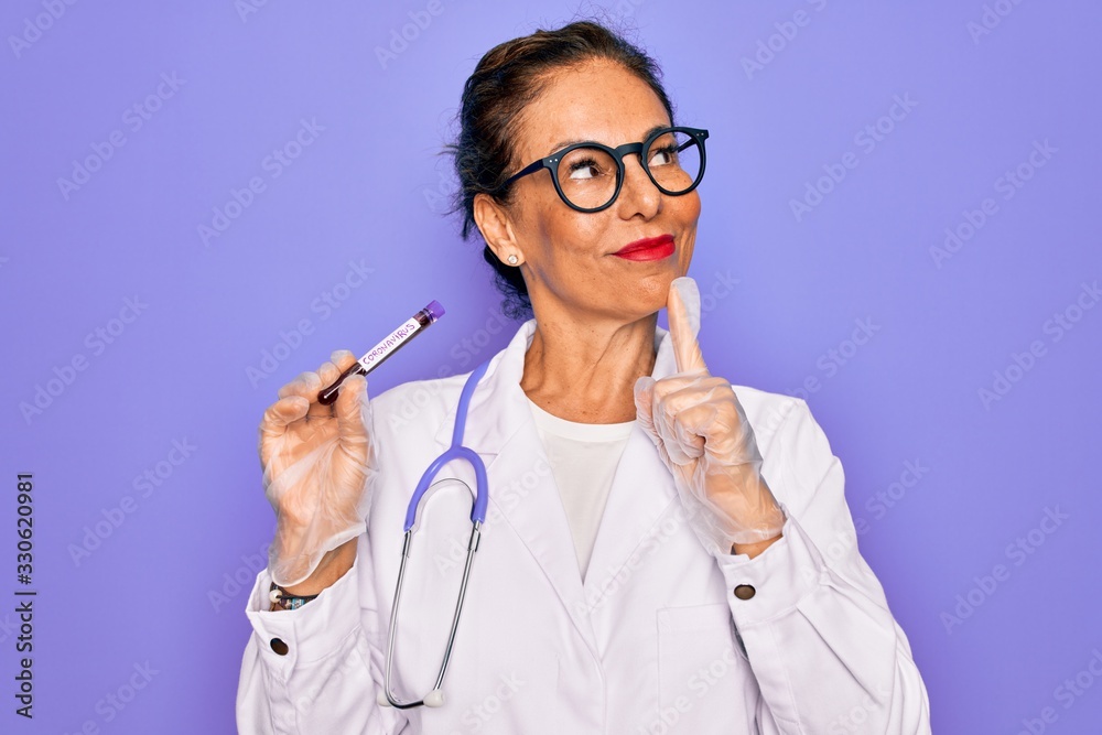Middle age senior female doctor holding medice blood sample of coronavirus infection disease serious face thinking about question, very confused idea Middle age senior female doctor holding medice blood sample of coronavirus infection disease serious face thinking about question, very confused idea