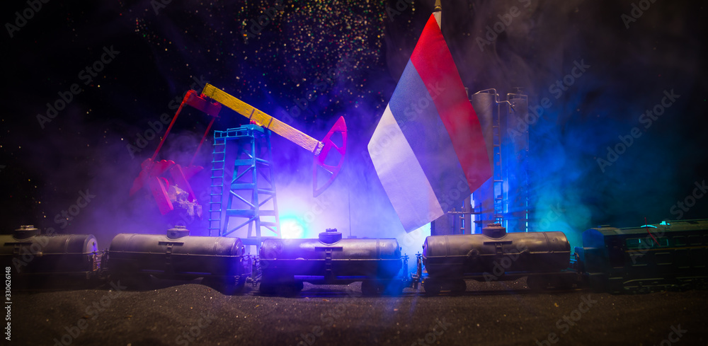 Business dialogue, oil agreement concept: National flags with Oil pump and oil refining factory at night with fog and backlight. Energy industrial concept. Business dialogue, oil agreement concept: National flags with Oil pump and oil refining factory at night with fog and backlight. Energy industrial concept.