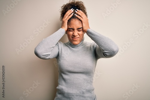 Beautiful african american girl wearing turtleneck sweater standing over white background suffering from headache desperate and stressed because pain and migraine. Hands on head.