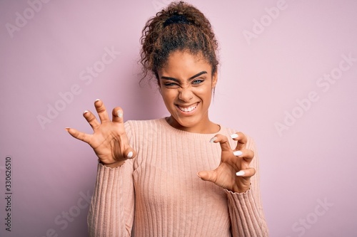Canvas Print Young beautiful african american girl wearing casual sweater standing over pink