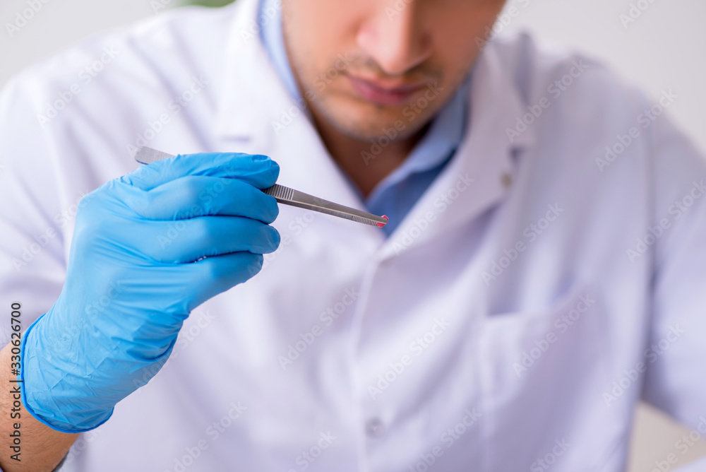 Young male lab assistant in drug synthesis concept Young male lab assistant in drug synthesis concept