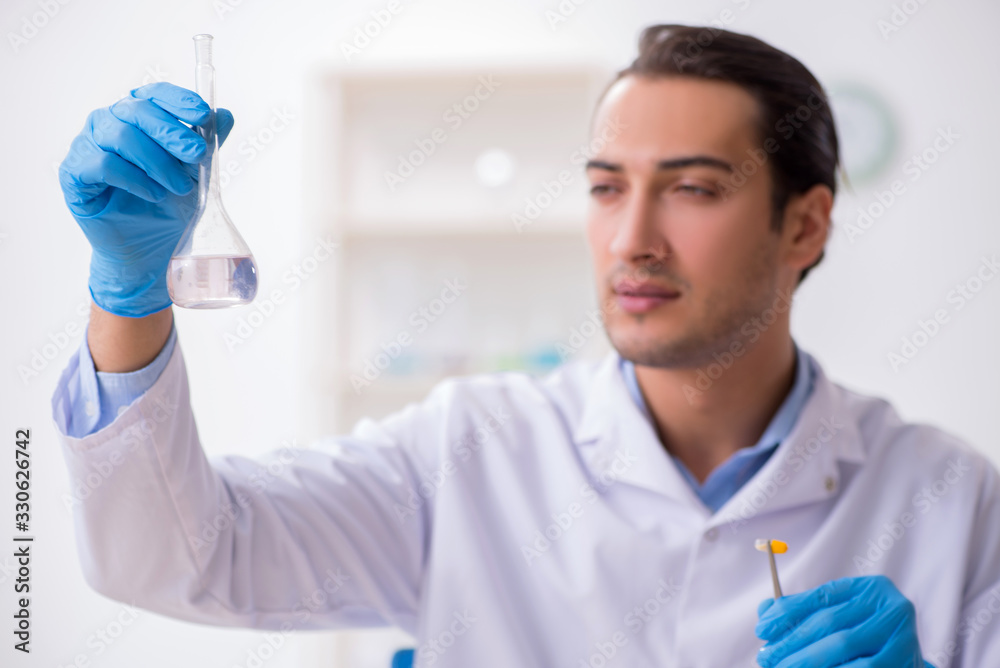 Young male lab assistant in drug synthesis concept Young male lab assistant in drug synthesis concept