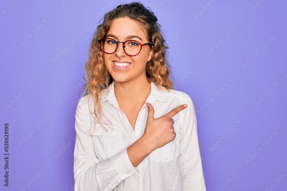 Young beautiful woman with blue eyes wearing casual shirt and glasses over purple background cheerful with a smile of face pointing with hand and finger up to the side happy and natural Young beautiful woman with blue eyes wearing casual shirt and glasses over purple background cheerful with a smile of face pointing with hand and finger up to the side happy and natural