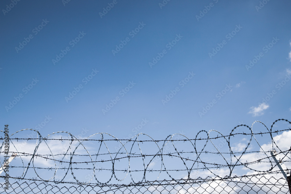 barbed wire on empty light blue sky background barbed wire on empty light blue sky background