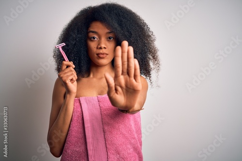 Принти на полотні Young african american woman with afro hair in a towel holding female razor for