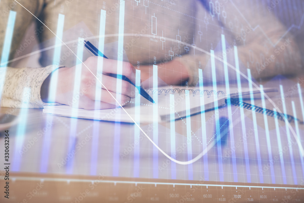 Hands writing information about stock market in notepad. Forex chart holograms in front. Concept of research. Multi exposure Hands writing information about stock market in notepad. Forex chart holograms in front. Concept of research. Multi exposure