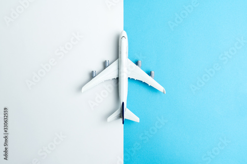 Flat lay miniature airplane model isolated on white and blue background © Kenishirotie
