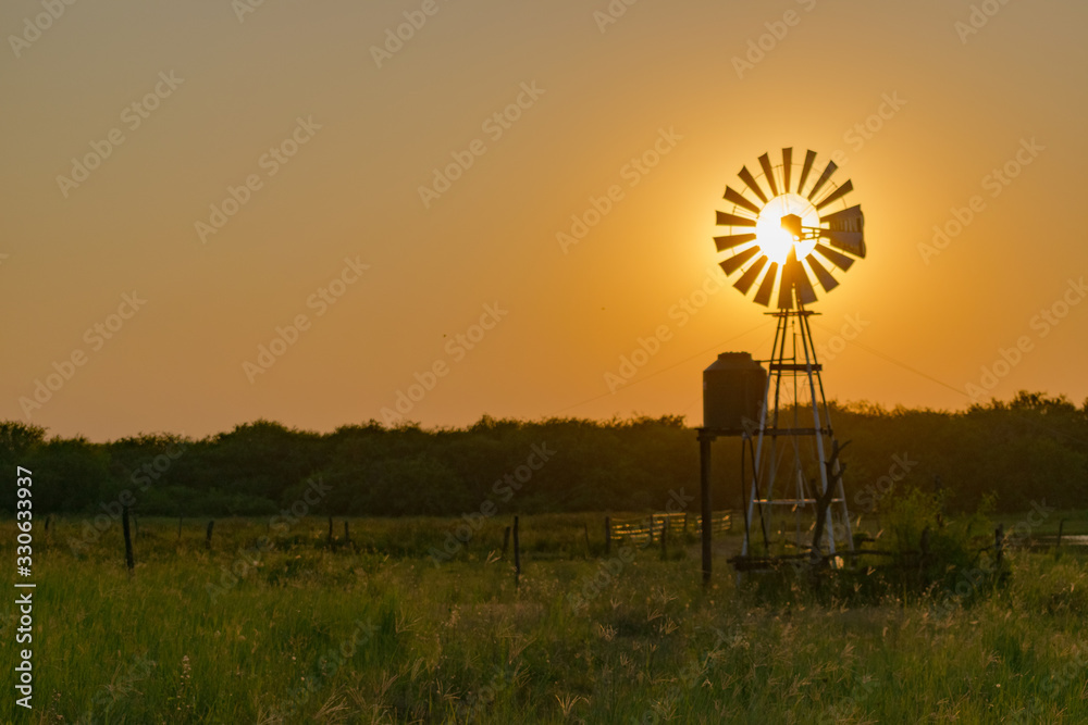 Molino de Viento Tapando el Sol al Atardecer, Castelli - Chaco - Argentina Molino de Viento Tapando el Sol al Atardecer, Castelli - Chaco - Argentina