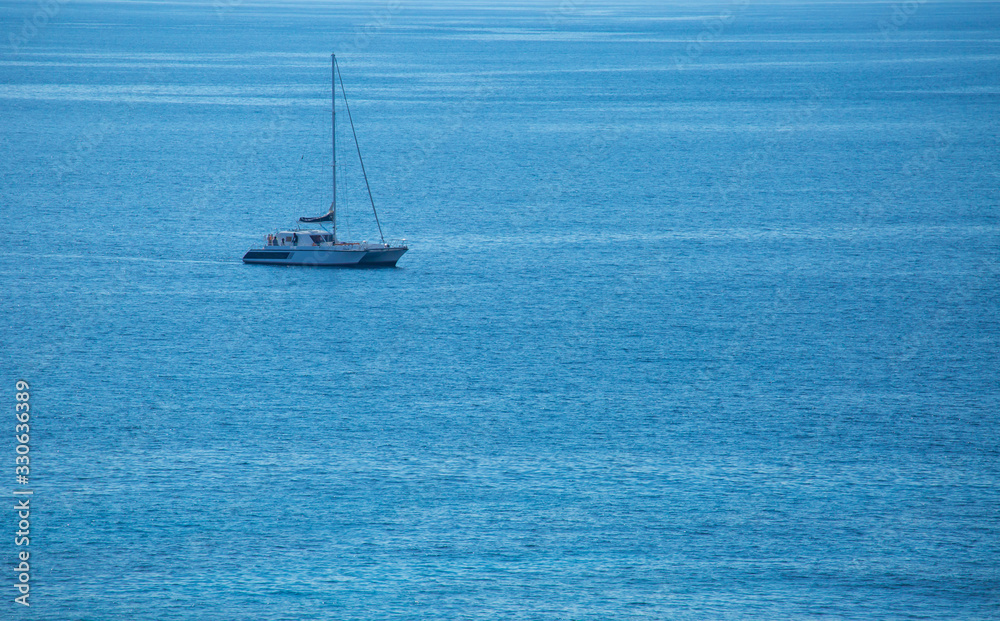 The yacht floats freely in the middle of the blue sea on a holiday.